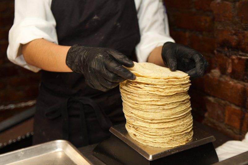 Finished tortillas are packed into thermal boxes to keep warm. Any that cool before being served are cut and fried for chips<br>